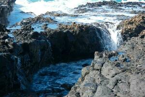 Large waves crashing against the rocks in the ocean photo