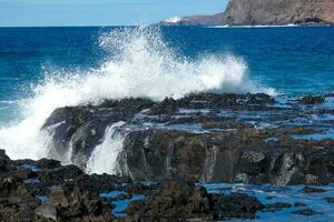 Large waves crashing against the rocks in the ocean photo