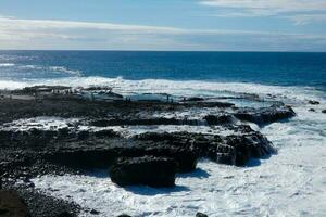 Large waves crashing against the rocks in the ocean photo