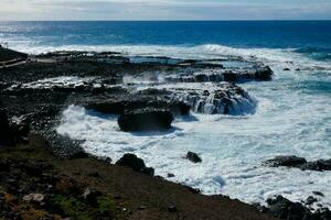 Large waves crashing against the rocks in the ocean photo