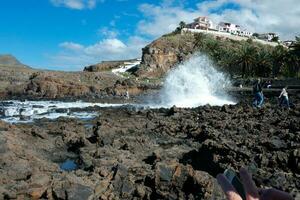 Large waves crashing against the rocks in the ocean photo