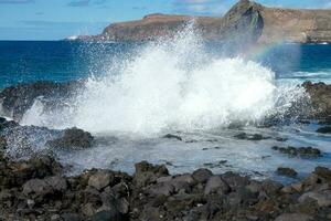 Large waves crashing against the rocks in the ocean photo