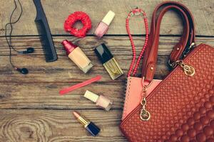 Things from open lady handbag. women's purse on wood background. Toned image. photo