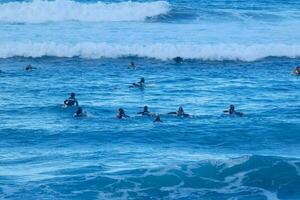 surfistas montando pequeño Oceano olas foto
