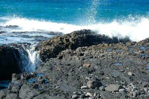 Large waves crashing against the rocks in the ocean photo