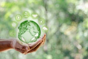 Environment World Earth Day. Technology earth global with icon in human hand on green nature background. Saving environment, save clean planet, ecology concept. Ecology and Sustainable Development. photo