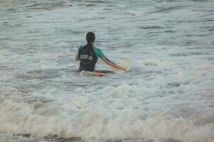 joven Atletas practicando el agua deporte de surf foto