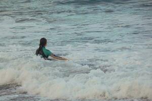 young athletes practising the water sport of surfing photo