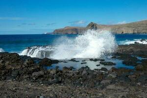 Large waves crashing against the rocks in the ocean photo