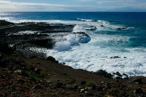 Large waves crashing against the rocks in the ocean photo