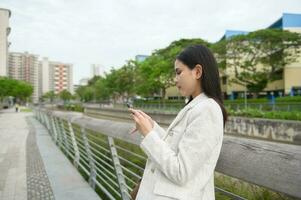 A young businesswoman is working in modern city downtown of Singapore photo