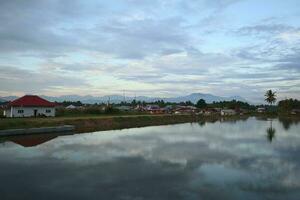 A village by the water with mountains in the background photo