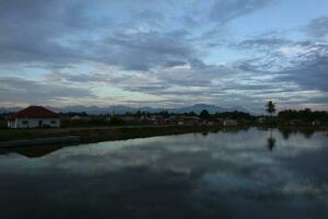 A village by the water with mountains in the background photo