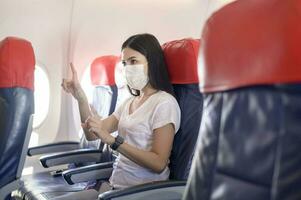 personas es conmovedor virtual pantalla en avión , moderno tecnología y transporte concepto. foto