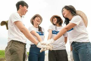 voluntarios desde el asiático juventud comunidad utilizando basura pantalones limpieza arriba naturaleza par foto