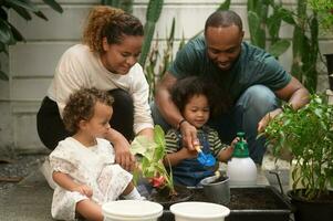 Happy African American family enjoying gardening at home photo