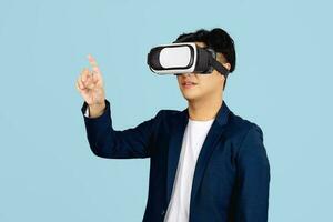 Asian using VR headset smile with hand pointing to space on web banner light blue background. photo