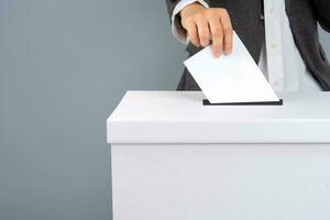 A voter holds vote ballot paper in the ballot box. Election concept. photo