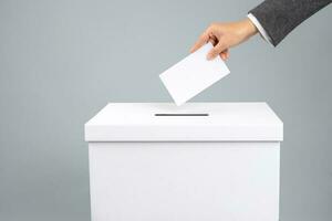 Man putting his vote into ballot box, closeup. The concept of free democratic vote elections. photo