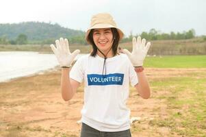 voluntarios desde el asiático juventud comunidad utilizando basura pantalones limpieza arriba naturaleza par foto
