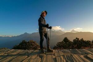 A young traveller trekking in Poon Hill view point in Ghorepani, Nepal photo