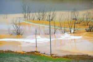 A lake contaminated with toxic waste in the western mountains of Romania. Nature pollution from copper mine. Ecological catastrophe or Environmental disaster photo