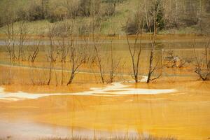 un lago contaminado con tóxico residuos en el occidental montañas de Rumania. naturaleza contaminación desde cobre mío. ecológico catástrofe o ambiental desastre foto