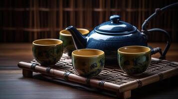 Warm cup of tea with teapot, green tea leaves and dried herbs on the bamboo mat at morning, photo