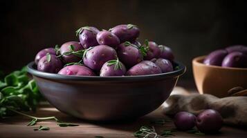 Bowl of raw purple potatoes, thyme and peeler, photo