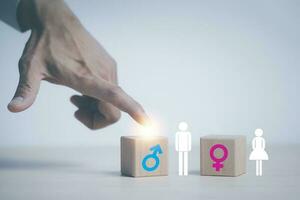 concept equality and differences between men and women, Hand touch wooden cube with male icon on top of cubes, gender discrimination in employment. Wooden blocks with male and female symbols. photo