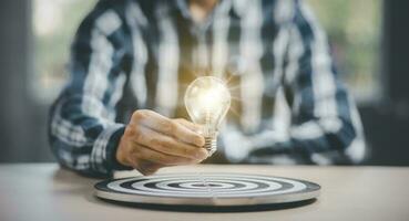 thinking and creative concept, Close up the light bulb and working on the desk, Creativity, novation are keys to success,  new idea and innovation with Brain and light bulbs, target dart board concept photo