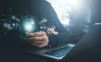 Businessman holding glowing light bulb with AI Data Management System on the computer, Hands working on a laptop cloud network graphic overlay, connected to the database. Corporate strategy finance photo