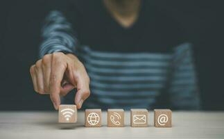 communication and technology concept , Hand putting wooden block cube symbol telephone, email, address. Website page contact us or e-mail marketing, Contact us in customer support concept photo