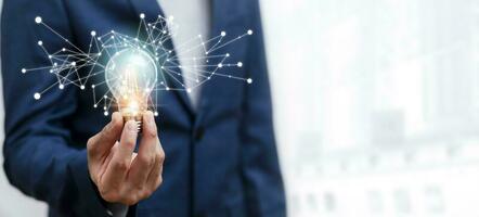 Creativity and innovation, Businessman hand hold light bulb with icons work on the desk, Creativity and innovation are keys success. Concept of new idea and innovation with icons and light bulbs, photo