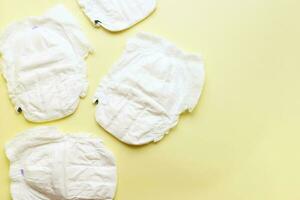 Flat lay panty diapers on yellow background top view. Baby hygiene item. Ecology, plastic photo
