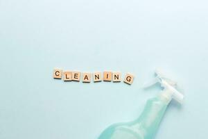 Word cleaning from wooden letters. Spray for cleaning. Cleaning agent. Purity. Flatly cleaning on a blue background photo