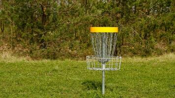 Dto golf cesta. frisbee golf es deporte y hobbie en al aire libre parque. metal cesta con cadenas para Dto juego rodeado por vibrante verde arboles foto
