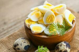 boiled eggs food, quail eggs on wooden bowl, breakfast eggs with fresh quail eggs and vegetable lettuce on table background photo