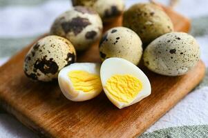 boiled eggs food, quail eggs on wooden plate, breakfast eggs with fresh quail eggs on table background photo