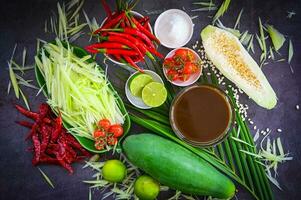 Thai food top view - papaya salad spicy with herbs and spices condiments and ingredients with chili tomato lemon lime papaya Slice, Thai Food Concept photo