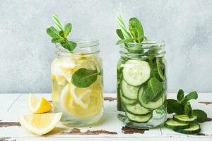 Detox water for healthy lifestyle. Fresh water in jar with lemon, cucumber and mint on wooden table. photo