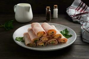 Ham and cheese rolls on a plate. Delicious appetizer meat carbonate and cream cheese. photo