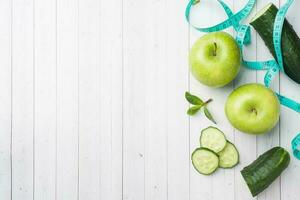 Green Apple mint cucumber on the table. The concept of diet and vegetarianism. Copy space. Measuring tape centimeter. photo