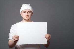 A man holds a blank white sign board mockup in his hand photo