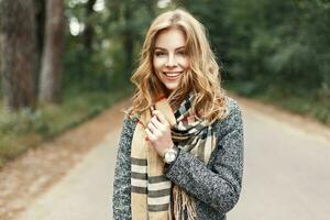 contento estilo de vida retrato de un hermosa joven modelo niña con un dulce sonrisa en un calentar otoño bufanda. foto