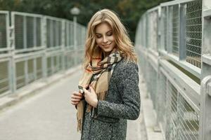 hermosa contento joven mujer en un otoño Saco con un bufanda. foto