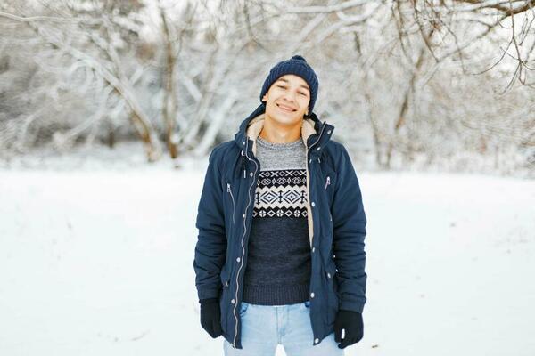 Young man in stylish winter clothes on a background of snowy park 23334381  Stock Photo at Vecteezy