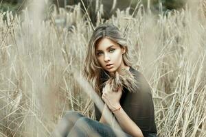 Pretty woman in black shirt sitting in a millet field photo