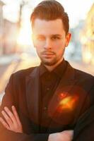 hermoso hombre con un barba y peinado en negro elegante traje a puesta de sol foto