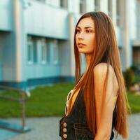 Beautiful brunette woman with long hair near the modern building. photo